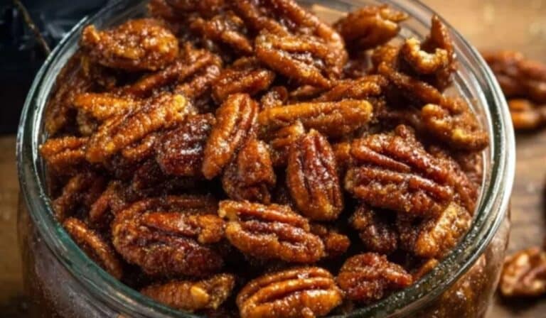 Slow Cooker Candied Pecans in glass jar with caramel glaze