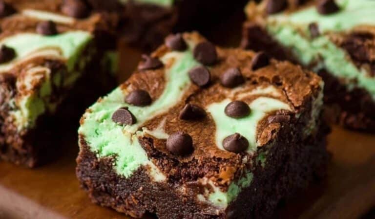 Mint Chocolate Chip Cheesecake Brownies swirled and sliced on rustic board