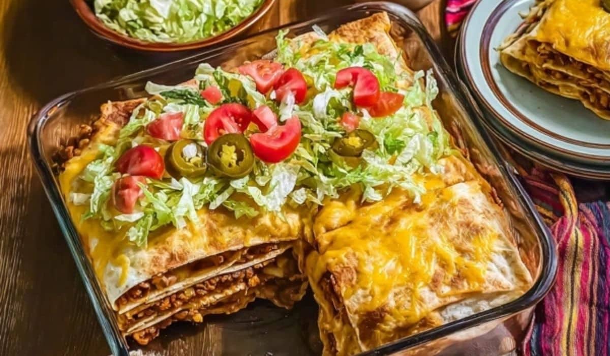 Crunchwrap casserole baked in a pan with golden cheese and fresh toppings