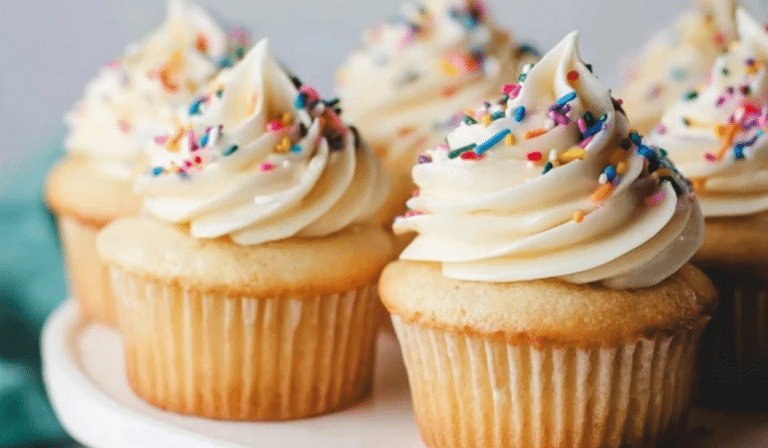 Perfect Vanilla Cupcakes with vanilla buttercream swirls on a cake stand