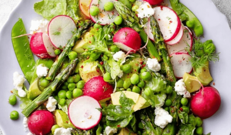 Spring Salad Recipe on a platter with asparagus, peas, radishes, and lemon dressing