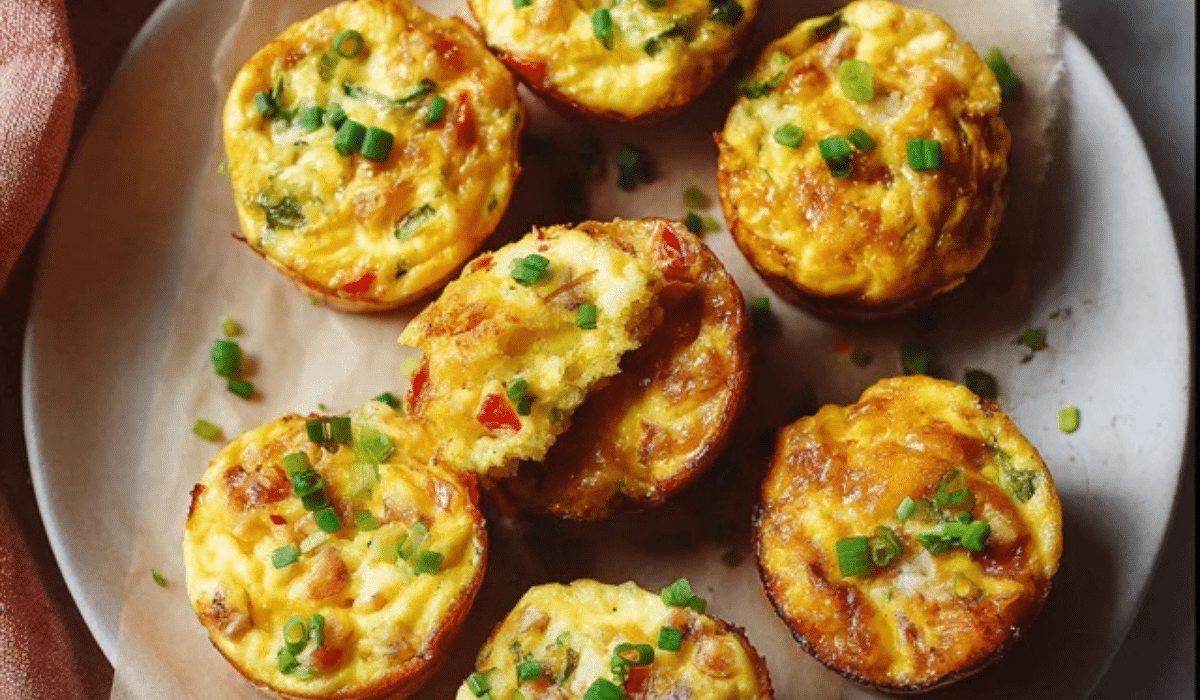 Breakfast Egg Muffins baked in a muffin tin with golden tops and chives