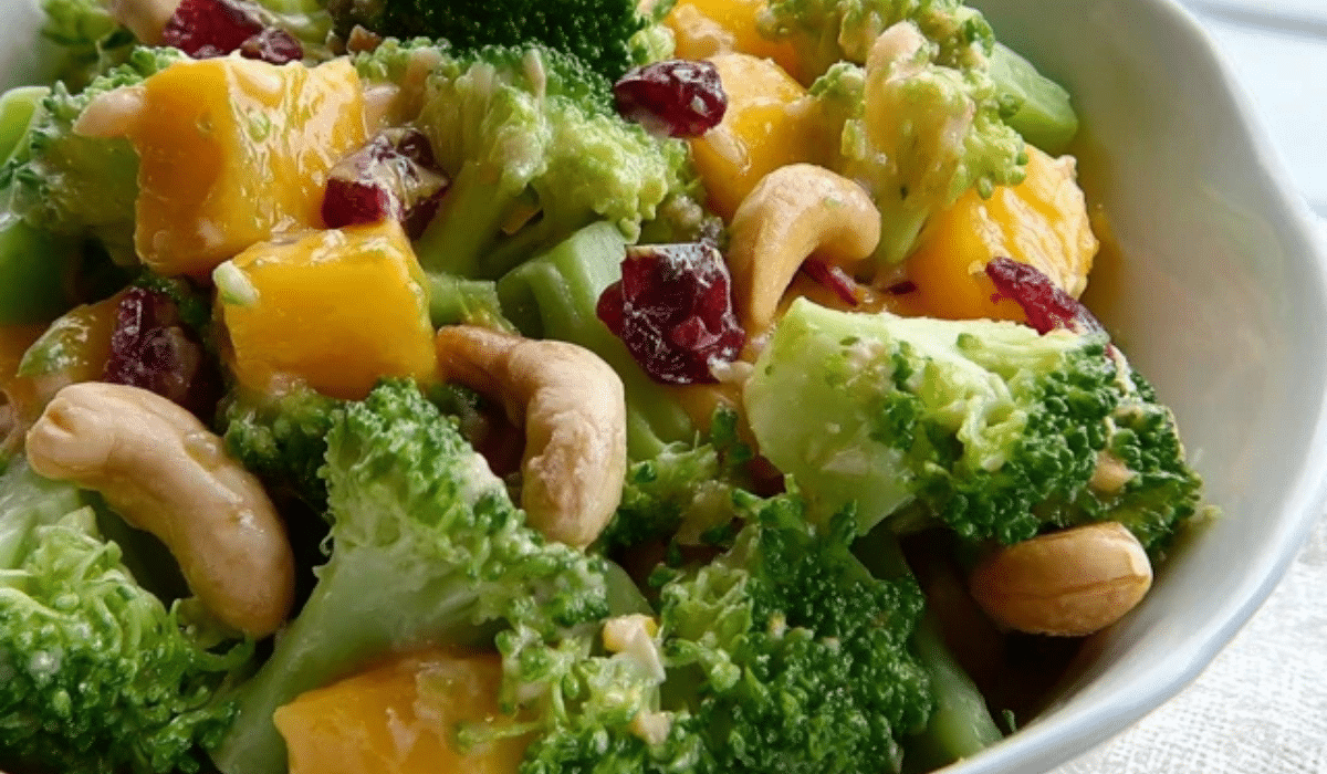 Broccoli Mango Salad with cashews, dried cranberries, and lime dressing in a serving bowl