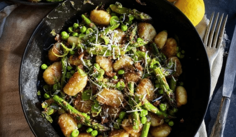 Brown Butter Gnocchi With Asparagus & Peas in a skillet with lemon and parmesan
