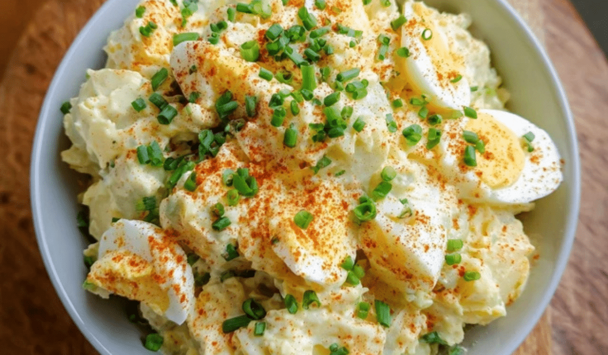 Deviled Egg Potato Salad in a bowl with paprika and chives