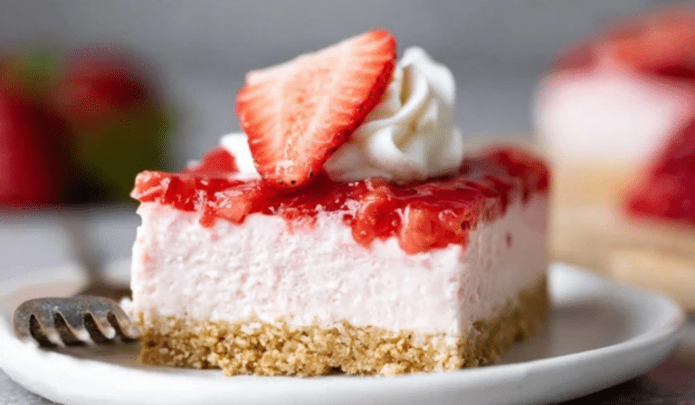 No-Bake Strawberry Cheesecake Bars sliced into clean squares with fresh strawberries