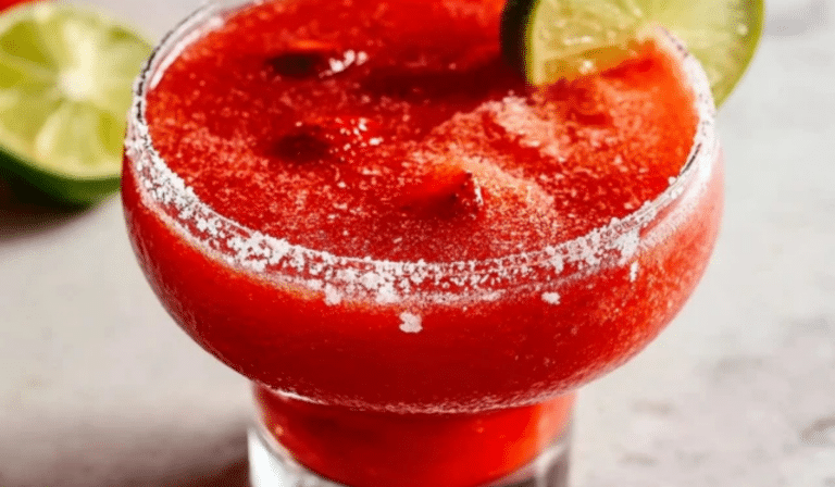 Frozen Strawberry Margarita in a salt-rimmed glass with lime