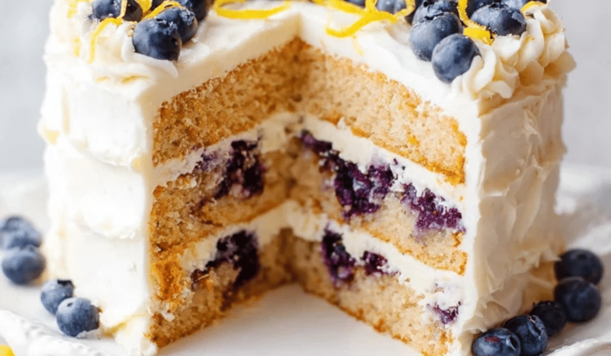 : Lemon Blueberry Layer Cake with cream cheese frosting on a cake stand