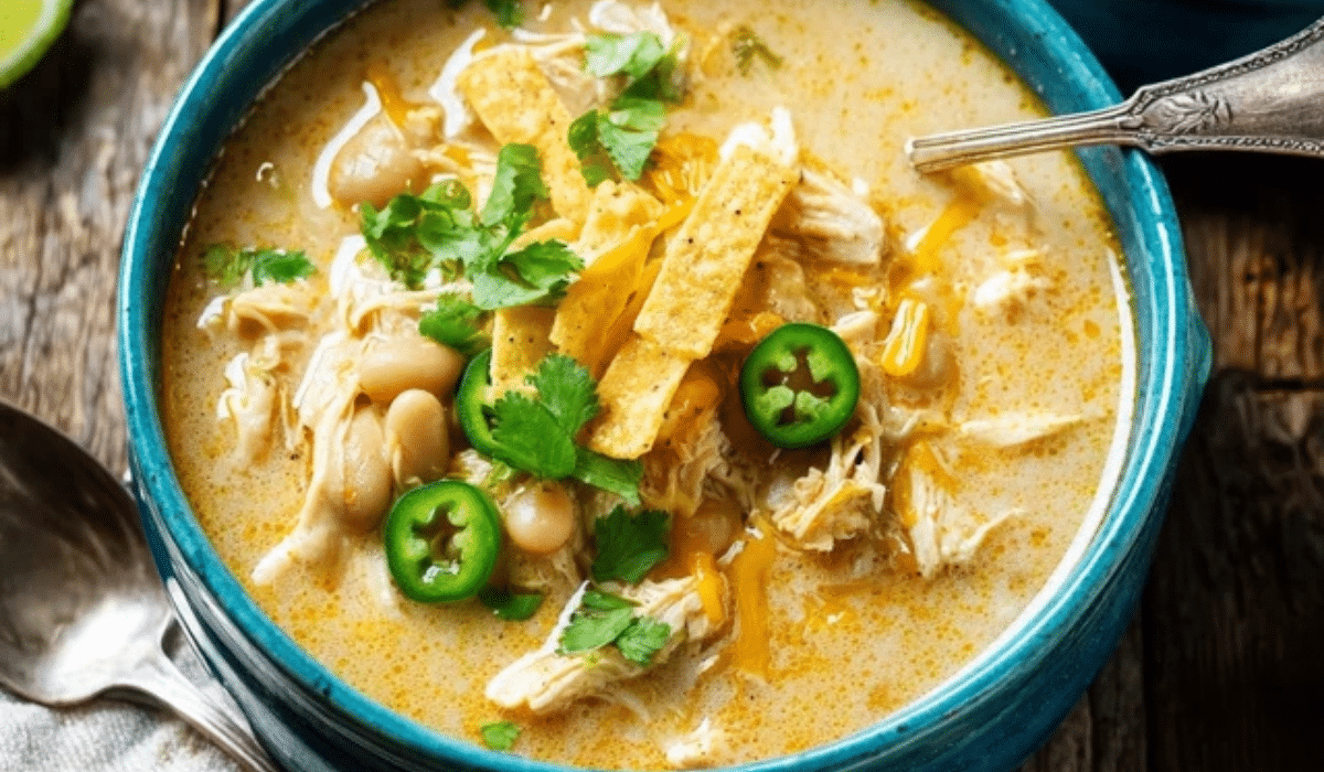 Slow Cooker White Chicken Chili topped with cilantro, lime, and tortilla strips